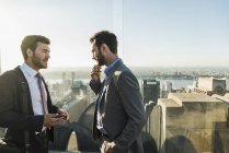 США, Нью-Йорк, два бизнесмена разговаривают на смотровой площадке Рокфеллеровского центра — стоковое фото