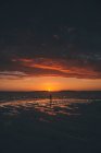 Francia, Bretagna, Landeda, Dunes de Sainte-Marguerite, paesaggio marino e spiaggia con donna sullo sfondo al tramonto — Foto stock