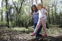 Mutter und Tochter im Park, Mädchen balanciert auf Baumstamm — Stockfoto