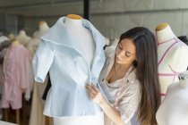 Jeune créateur de mode ajustant des vêtements sur le modèle de couturière — Photo de stock