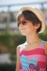 Portrait of little girl with sunglasses and sun hat, looking sideways — Stock Photo
