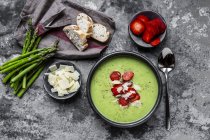Sopa de crema de espárragos verdes con fresa, parmesano y baguette - foto de stock