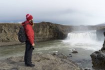 Islanda, nord dell'Islanda, giovane che guarda alla cascata — Foto stock