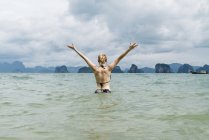 Таиланд, Ко Яо Ной, вид сзади счастливой женщины, стоящей в море — стоковое фото