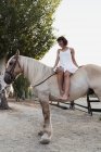 Barefoot woman sitting bareback on horse — Stock Photo