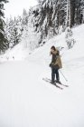 Porträt einer glücklichen jungen Frau beim Skifahren im Winterwald — Stockfoto