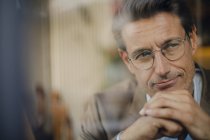 Homme d'affaires mature assis dans un café, regardant par la fenêtre — Photo de stock