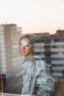 Portrait de jeune femme derrière vitre avec reflet de la ville — Photo de stock