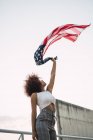 Young woman swinging American flag against clear sky — Stock Photo