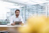 Jungunternehmer mit Tablet im Café — Stockfoto