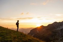 Man standing in mountains at sunset — Stock Photo