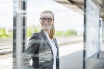 Portrait of smiling businesswoman waiting at platform — Stock Photo