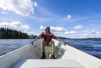 Finlandia, Hombre remando en un barco en un lago - foto de stock