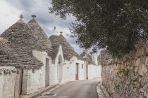 Itália, Apúlia, Alberobello, vista para o beco com tipicamente Trulli — Fotografia de Stock