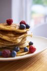 Pile on pancakes on plate with berries — Stock Photo