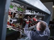 Worker in factory repairing engine block — Stock Photo