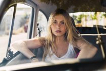 Retrato de uma jovem sentada em um carro — Fotografia de Stock