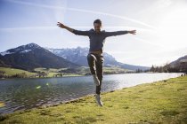Австрія, Тіроль, Вальчзе, щасливий чоловік, що стрибає на озеро. — стокове фото
