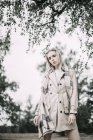 Ritratto di giovane donna alla moda che indossa cappotto e sciarpa in natura e posa sulla macchina fotografica — Foto stock