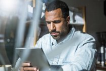 Man using tablet in a cafe — Stock Photo