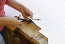 Primer plano del papel de corte de mujer del borrador en el taller de vidriero - foto de stock