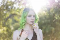 Портрет молодої жінки з фарбованим зеленим волоссям і бровами при підсвітку — стокове фото
