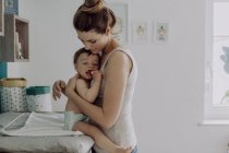 Mamma che cambia i pannolini del bambino a casa — Foto stock