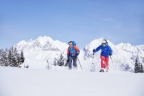 Austria, Tyrol, snowshoe hikers running through snow — Stock Photo