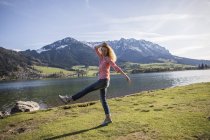 Áustria, Tirol, Walchsee, mulher feliz caminhando no lago — Fotografia de Stock