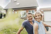 Ritratto di coppia matura sorridente seduta in giardino di casa — Foto stock