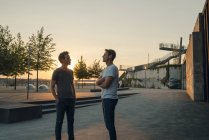 Two friends meeting at sunset, spending the evening talking — Stock Photo