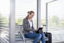 Smiling mature businesswoman using tablet while waiting at platform — Stock Photo