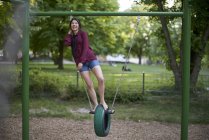Ridere giovane donna divertendosi su un'altalena — Foto stock