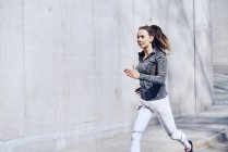 Жіночий бігун, бетонна стіна — стокове фото