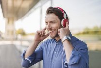 Retrato del hombre feliz escuchando música con auriculares - foto de stock