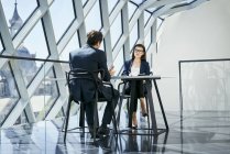 Geschäftsfrau und Geschäftsmann im Gespräch am Schreibtisch im modernen Büro — Stockfoto