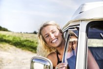 Mulher feliz olhando pela janela de uma van — Fotografia de Stock