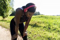 Junge Sportler in der Natur, Musik mit Kopfhörern hören, sich auf das Training vorbereiten — Stockfoto