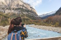 Spain, Ordesa and Monte Perdido National Park, back view of woman with backpack taking photo — Stock Photo
