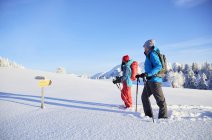 Austria, Tyrol, couple snowshoeing, standing in front of sign post — Stock Photo