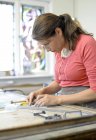 Woman working at workbench in glazier's workshop — Stock Photo