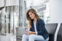 Молодий підприємець сидячи в зоні очікування за допомогою планшета — стокове фото