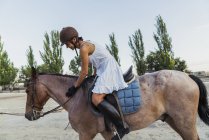 Woman in helmet riding on horse outdoors — Stock Photo