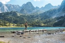 Áustria, Tirol, Jovem no Lago Seebensee equilibrando em tronco de árvore — Fotografia de Stock