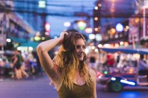 Thaïlande, Bangkok, jeune femme dans la ville dans la rue la nuit — Photo de stock