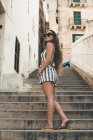 Ragazza adolescente che indossa abiti da spiaggia a strisce, in posa sulle scale — Foto stock