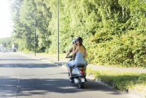 Glückliches Paar fährt im Sommer Motorroller — Stockfoto