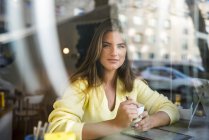 Portrait de jeune femme souriante dans un café — Photo de stock