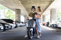 Casal feliz com scooter motor em underpass — Fotografia de Stock
