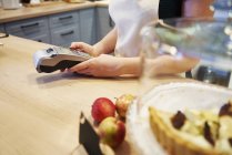 Waitress holding card reader at counter in a cafe — Stock Photo